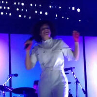 Incredibly beautiful desirable married singer Régine Chassagne openly joking about forbidden sex, on stage. Pointing out that every single black guy in the audience, wants to bang her. Gladly betraying their girlfriends & wives, without any hesitation. Because they’re all deeply in love with her.